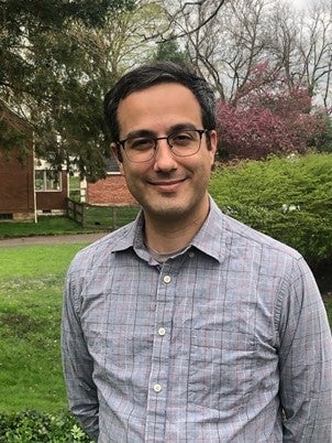 Image of Brian Canini standing outside near grass and bushes