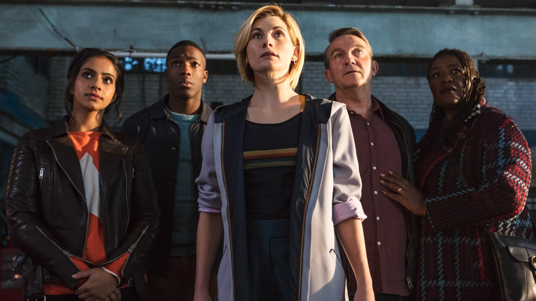 Image of Jodie Whittaker as the Doctor, with her companions behind her