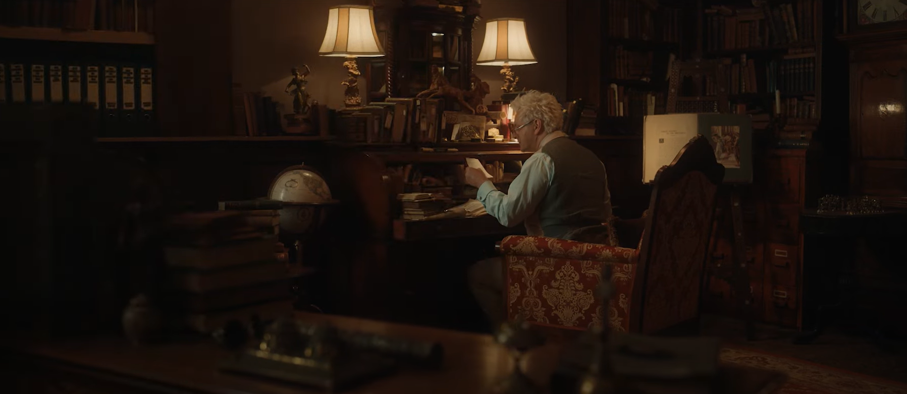 Aziraphale sitting at a desk