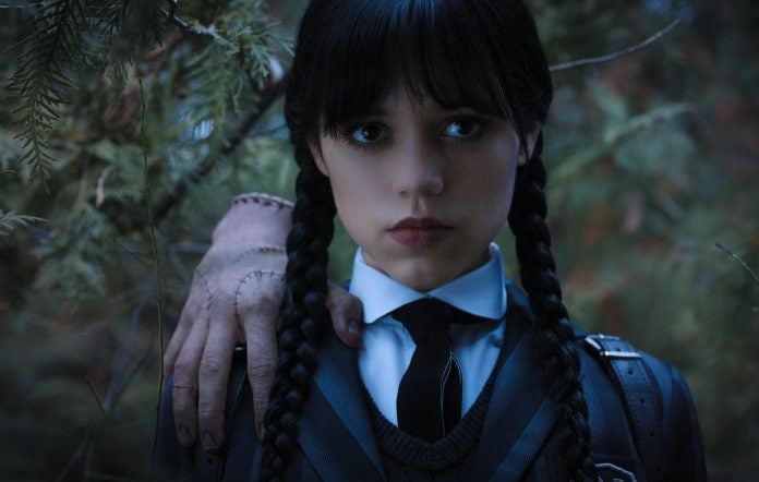 Still image of Wednesday with Thing perched on her shoulder